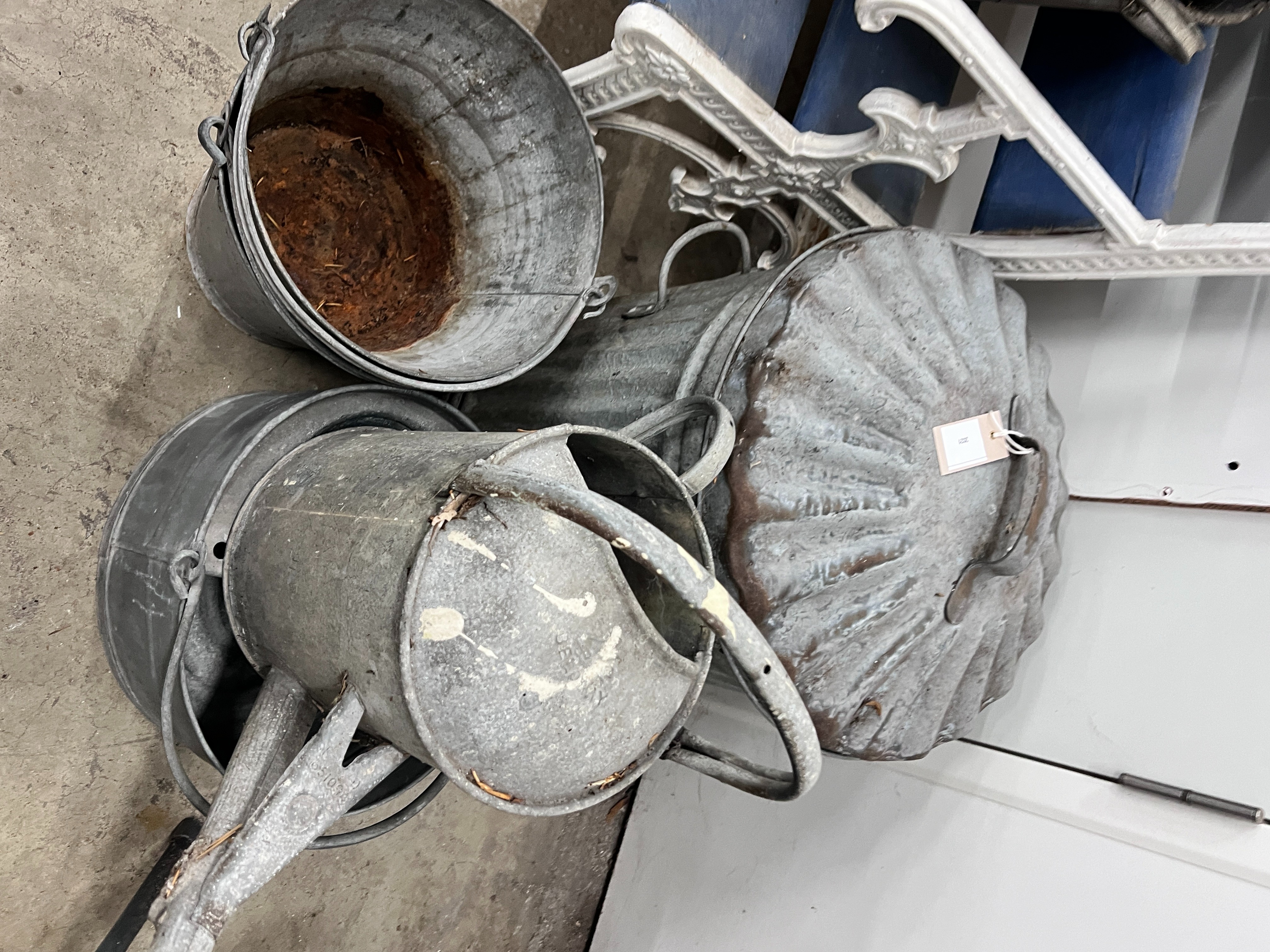 Ten assorted galvanised watering cans and containers, largest width 86cm